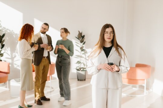 Young woman feeling excluded during business office break
