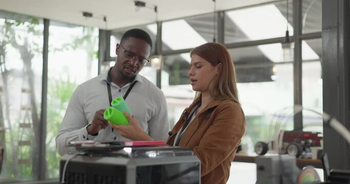 A diverse team of startup professionals collaborates on a 3D printing project in a modern workspace. Highlighting innovation, teamwork, and the prototyping process in a creative tech environment.
