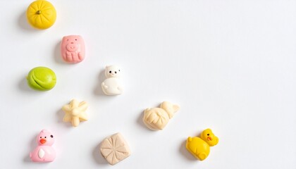 Obraz premium Minimalist flat lay image featuring various cute colorful confectionery wagashi or marzipan treats delightful animal shapes and small fruits on a clean bright white surface studio shot overhead view