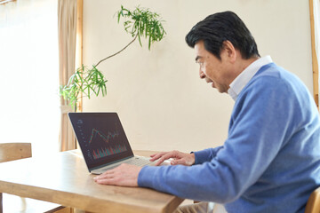 株取引をするアジア人シニア男性