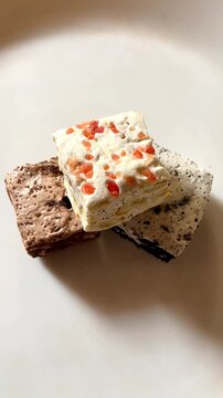 Classic Italian nougat with strawberry, chocolate and biscuit flavors on a white plate.