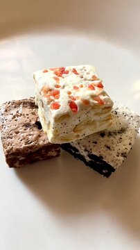 Classic Italian nougat with strawberry, chocolate and biscuit flavors on a white plate.