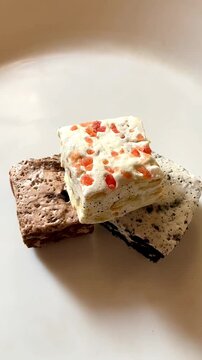 Classic Italian nougat with strawberry, chocolate and biscuit flavors on a white plate.