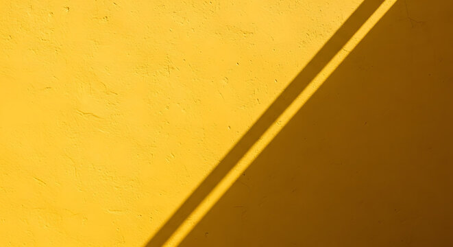 Bright yellow textured stucco wall background with sharp diagona