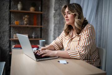 Fototapeta premium Woman working on laptop achieving remote productivity