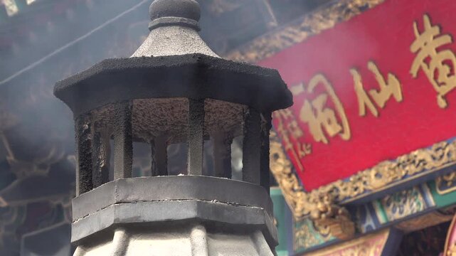 Close-up of incense burning oven and traditional characters on fa&ccedil;ade of Wong Tai Sin temple in Hong Kong
