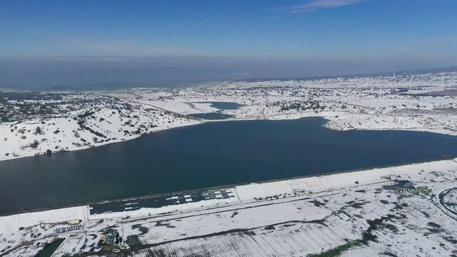 Aerial view of a snowy Bental reservoir in winter in the Golan Heights