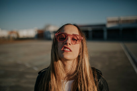 Portrait of young woman with defiant attitude wearing sunglasses outdoors