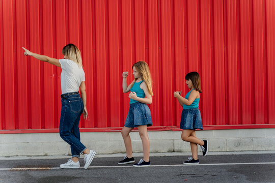 Mother showing with her finger, daughters following