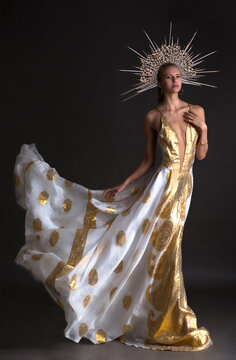 Young woman wearing dress with low neckline and headpiece