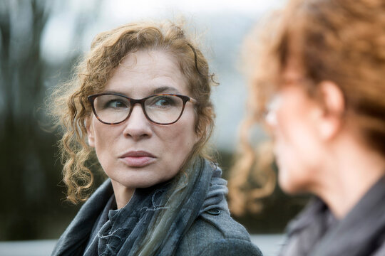 Portrait of mature woman, pensive, mirror image