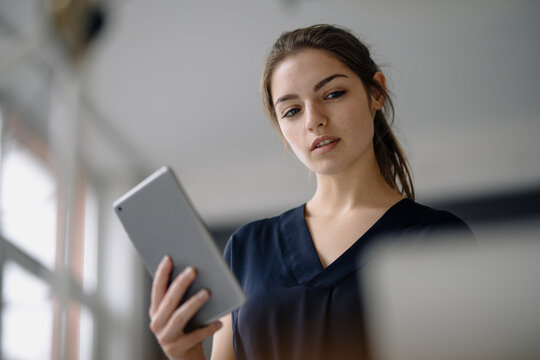 Portrait of young businesswoman with digital tablet in office