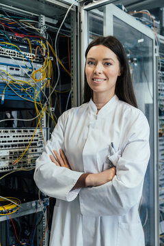 Female IT professional with arms crossed standing in server room