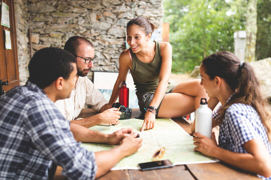 Group of hikers sitting together planning a hiking route looking at map
