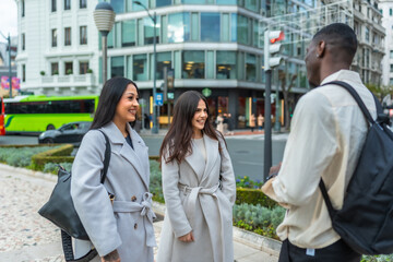 Fototapeta premium Young diverse friends meeting on city street for conversation