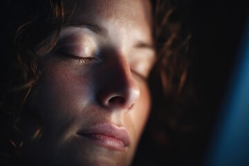 Fototapeta premium With her eyes gently closed, a woman finds solace from screen strain, softly illuminated in a tranquil setting after working on her laptop