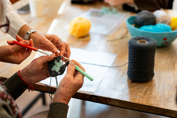 Hands crocheting yarn together in craft workshop © Alfonso Soler