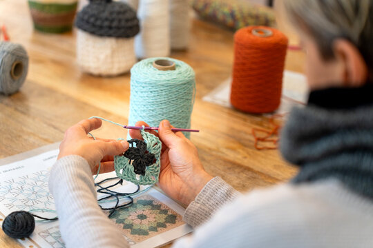 Woman crocheting granny square at home hobby craft