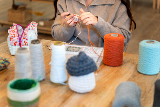 Woman crocheting creating handmade crafts at home