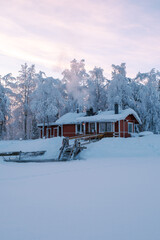 Winter wonderland in Akaslompolo village showcases cozy cabin amidst snowy landscape