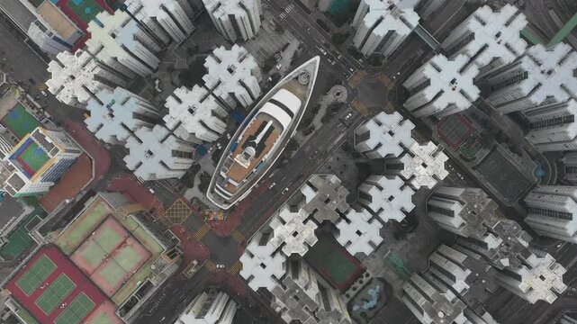 Overhead drone flight over peculiar cruise ship shaped commercial shopping mall in residential neighborhood of Hong Kong
