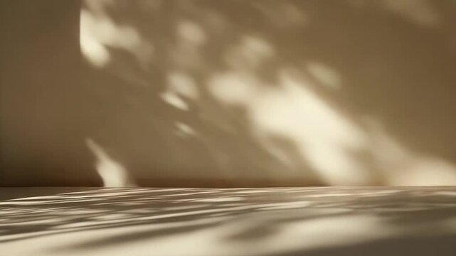 Warm light creates abstract leaves shadows on a simple beige wall and floor, providing a natural aesthetic background for product display and branding
