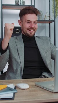 Concentrated businessman winner in suit working on laptop at home office desk typing browsing say Wow yes found out great big lottery win good news celebrate. Male manager freelancer man occupation