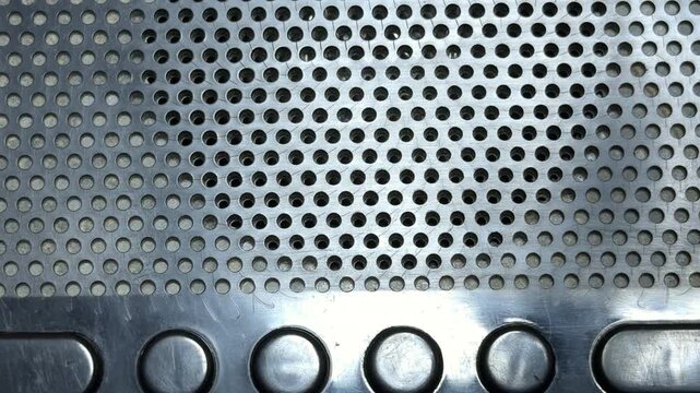 The internal speaker of the alarm clock transmits an unassigned frequency through its perforated metal grille. This electronic broadcast creates a constant, soothing hiss of radio white noise.