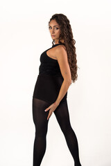 Fototapeta premium Female dancer posing in black attire looking at camera