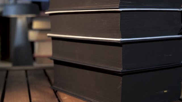 Close-up stack of hardcover volumes on wooden study table, Detailed view of thick printed materials symbolizing learning and research
