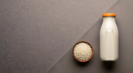 Fototapeta premium Bottle of Milk and Bowl of Rice on a Textured Gray Surface
