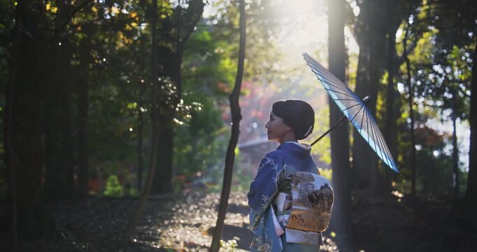 Cinematic, beautiful composed shot of Japanese woman in kimono holding umbrella in chilly forest