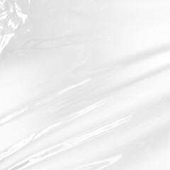 Obraz premium Wrinkled clear plastic wrap texture with white background highlight for product packaging design overlay and glossy cellophane material texture for creative visual effects compositions