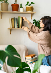 Woman organizing old books on wooden shelf