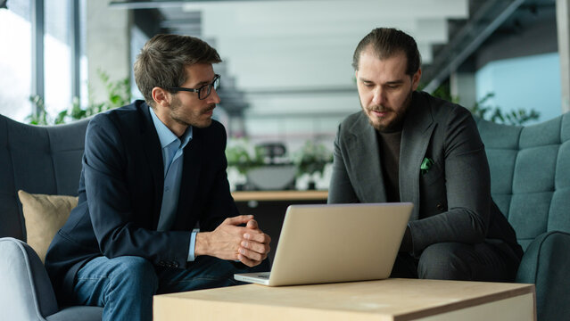 Businessmen discussing deal, sharing startup ideas, business partners negotiations or job interview in modern office