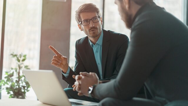 Businessmen discussing deal, sharing startup ideas, business partners negotiations or job interview in modern office