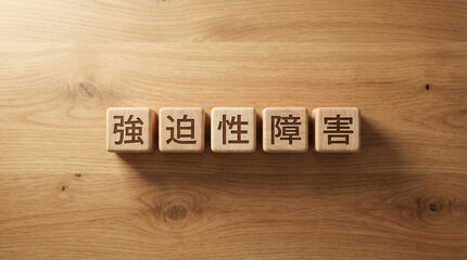 強迫性障害の文字が刻まれた木製ブロックが木の板の上に並ぶ | ナチュラルウッド