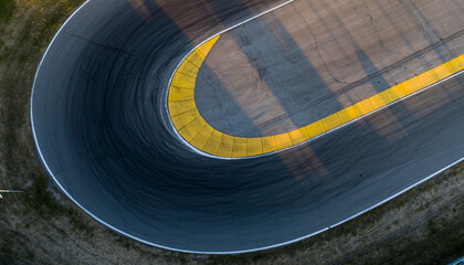 Aerial view of a curved race track with yellow markings.