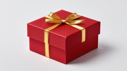 Elegant red gift box with golden ribbon lying on a white background, perfect for holidays or special occasions, conveying a sense of celebration and joy.