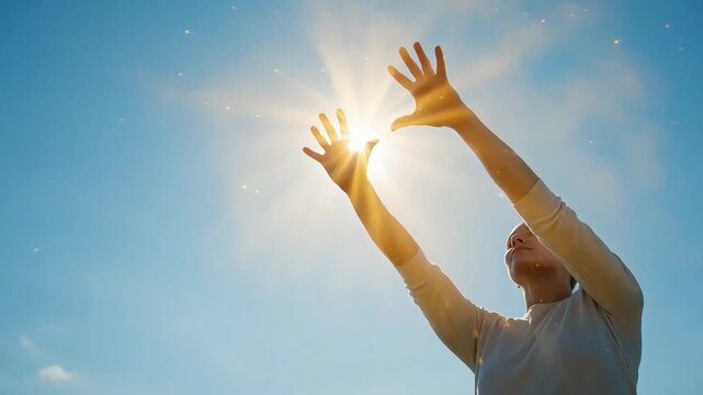 A woman reaches her hands towards the sun, embracing its energy and light for natural immune support under a clear blue sky.