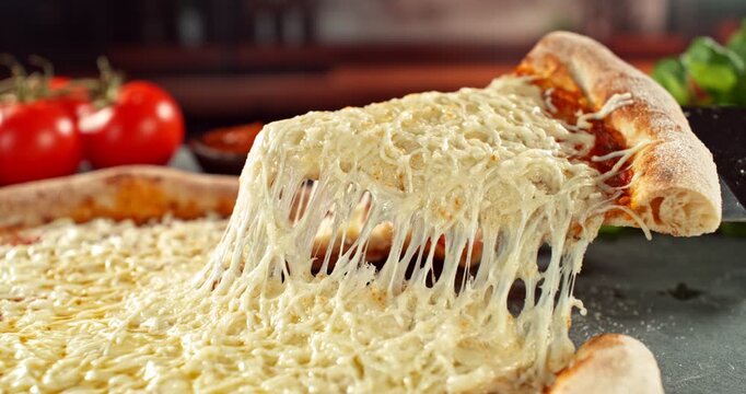 Super slow motion footage (1000 fps) of a pizza slice being lifted with perfectly melted, stretchy cheese. Rich textures of crust and fresh cheese in cinematic light.
