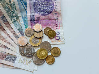 Different polish zloty banknotes and coins on white background close up. Official currency in Poland.