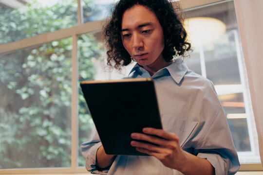 Focused Individual Deeply Immersed In Tablet Analysis Amid Serene Natural Background Environment