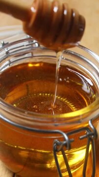honey dripping from a jar. Vertical video