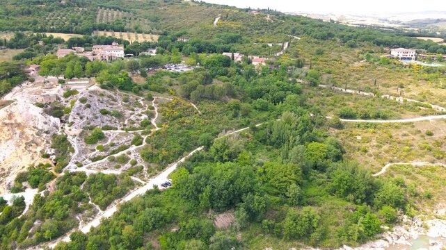 Bagno Vignoni natural pools along the city hill in Tuscany, view in spring season from drone