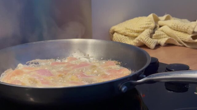 Pieces of meat are fried in a frying pan. Chicken is cooked in oil on the stove. Close-up. Homemade food. Healthy eating.