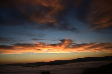 Fototapeta premium stunning view of a sunrise between fog ans sky