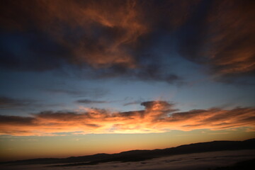Fototapeta premium stunning view of a sunrise between fog ans sky