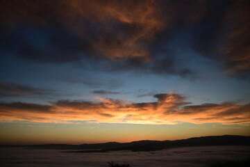 Obraz premium stunning view of a sunrise between fog ans sky