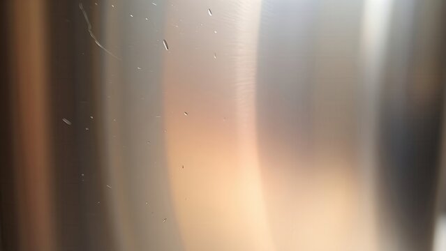 Metal surface transitioning from rough matte to glossy finish with light reflections.